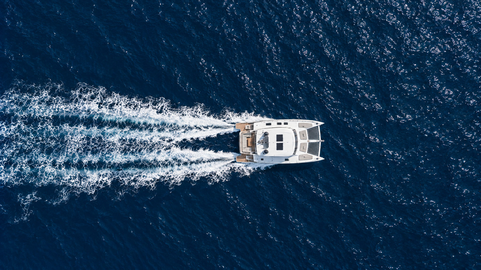 Private catamaran crossing deep blue Aegean water